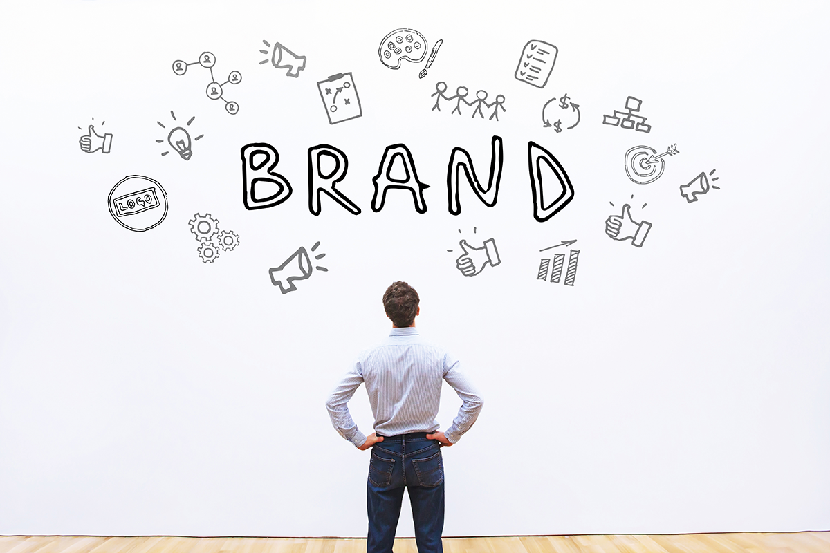 A man is standing in front of a wall that reads "Brand", with icons surrounding the word brand.