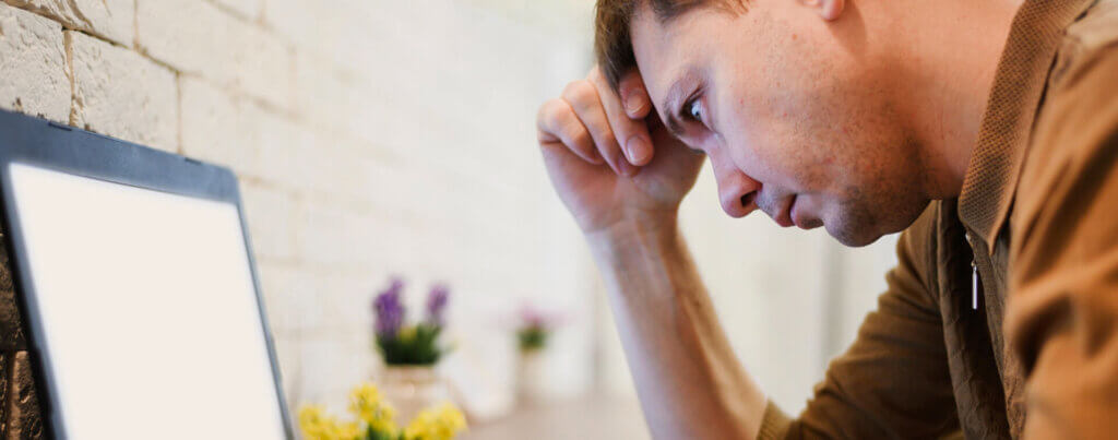 man looking at laptop annoyed