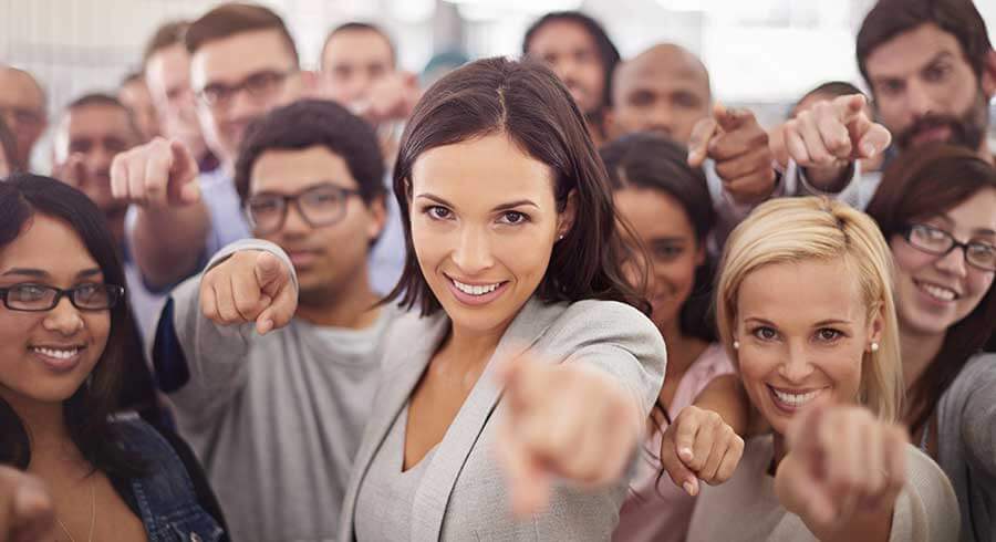 portrait of a group of smiling businesspeople pointing