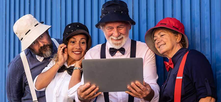 four men standing looking a website in amazement.