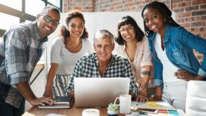 Members of a small business standing at a laptop.